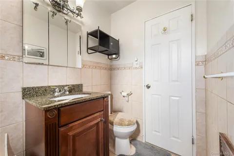 a bathroom with a granite countertop toilet sink and mirror