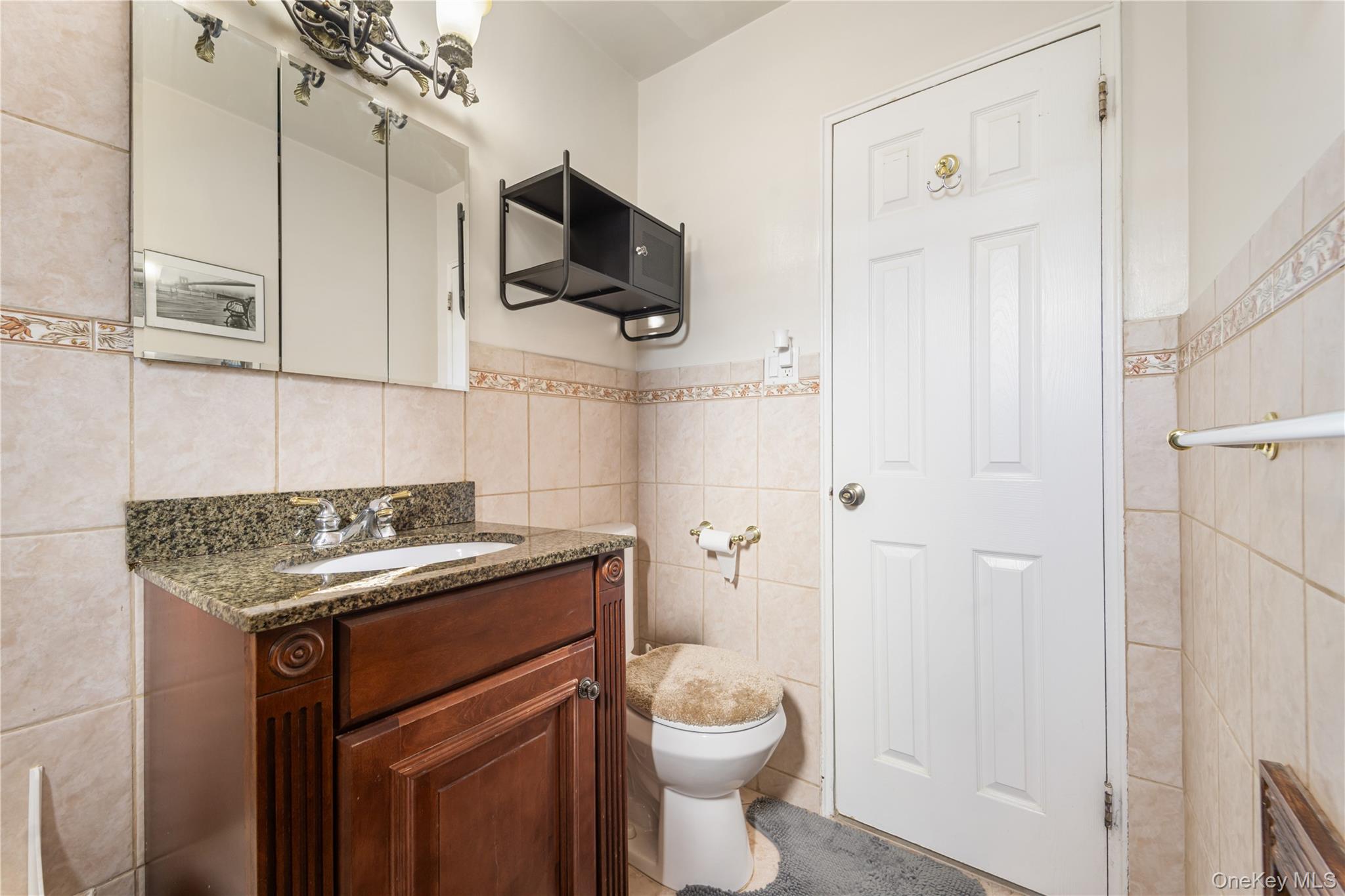 211-40 18th Avenue, Unit 6J Queens, NY 11360 - Photo 12 of 26 a bathroom with a granite countertop toilet sink and mirror