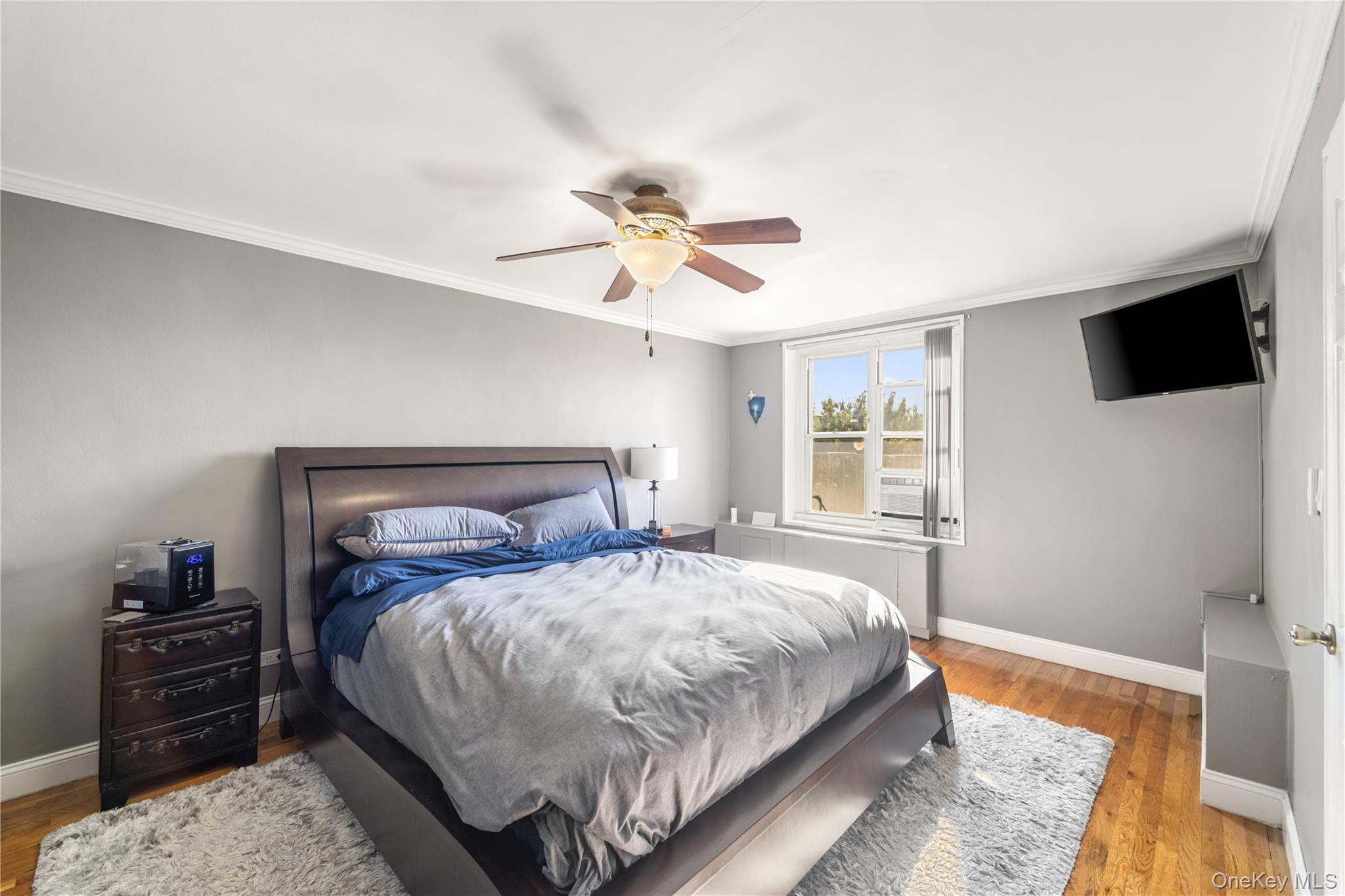 211-40 18th Avenue, Unit 6J Queens, NY 11360 - Photo 14 of 26 a bedroom with a bed and a tv