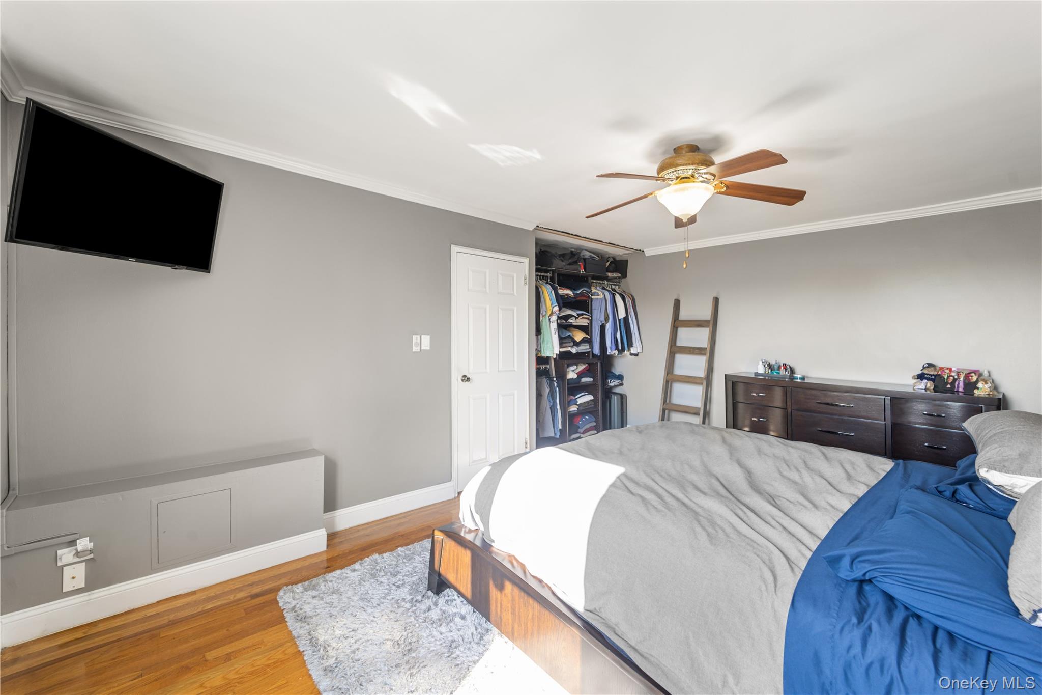 211-40 18th Avenue, Unit 6J Queens, NY 11360 - Photo 16 of 26 a spacious bedroom with a bed and a flat screen tv