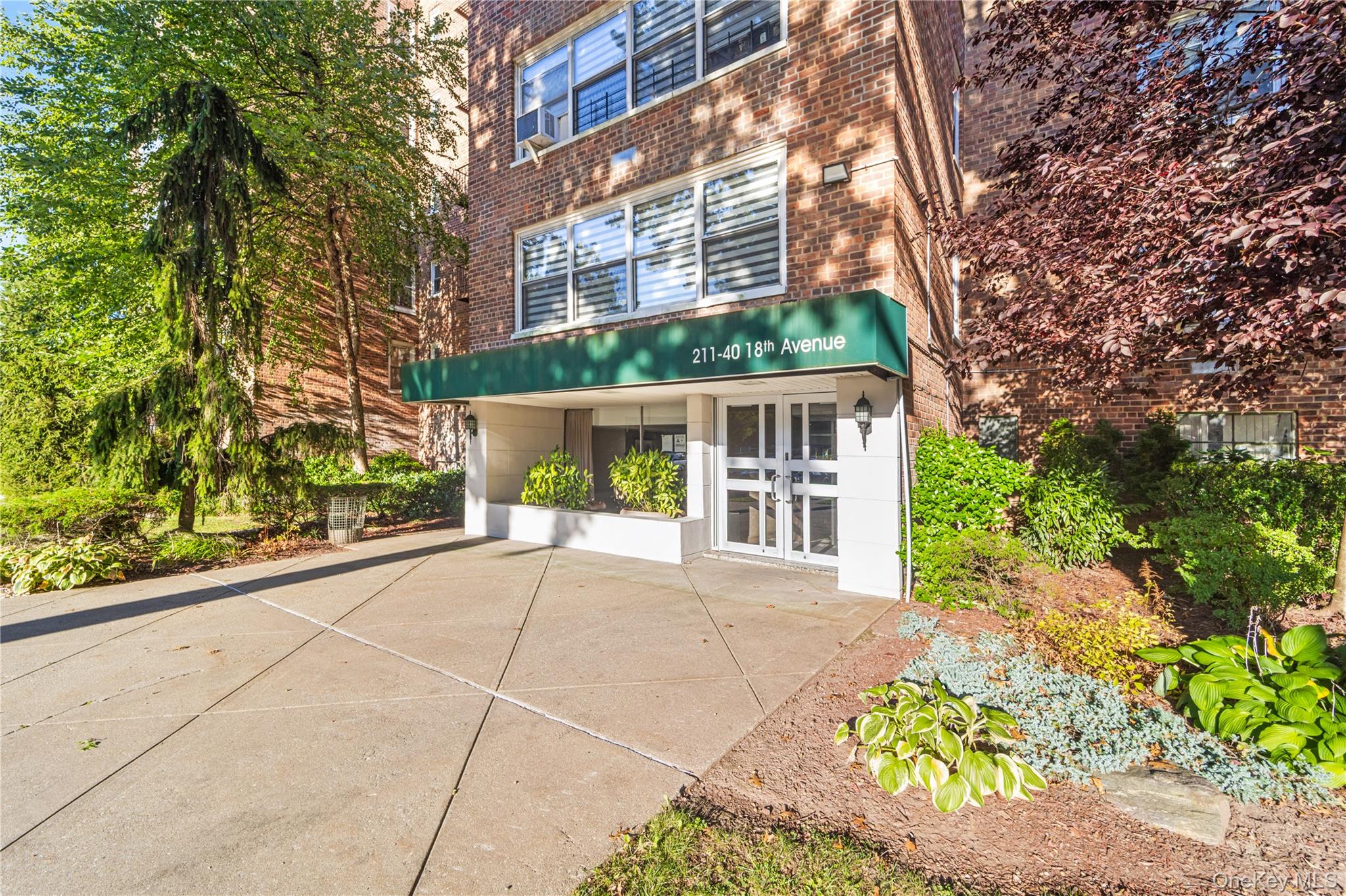 211-40 18th Avenue, Unit 6J Queens, NY 11360 - Photo 25 of 26 a view of a building with a yard