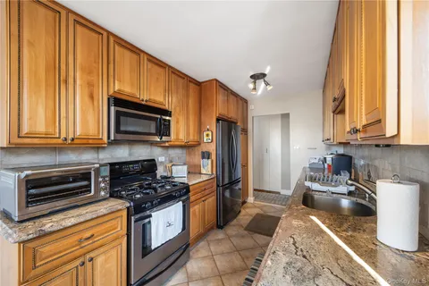 a kitchen with stainless steel appliances granite countertop a stove a sink and a microwave
