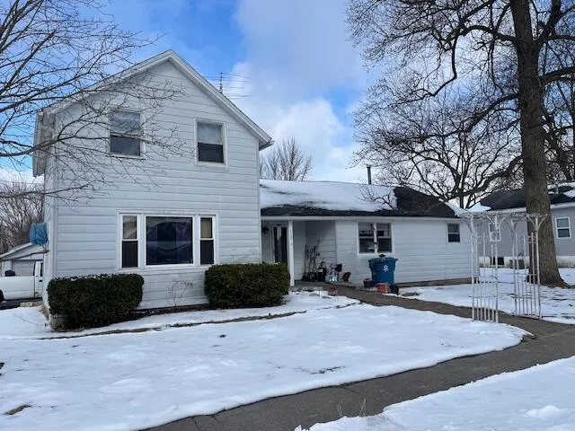 a view of a house with a yard and large tree