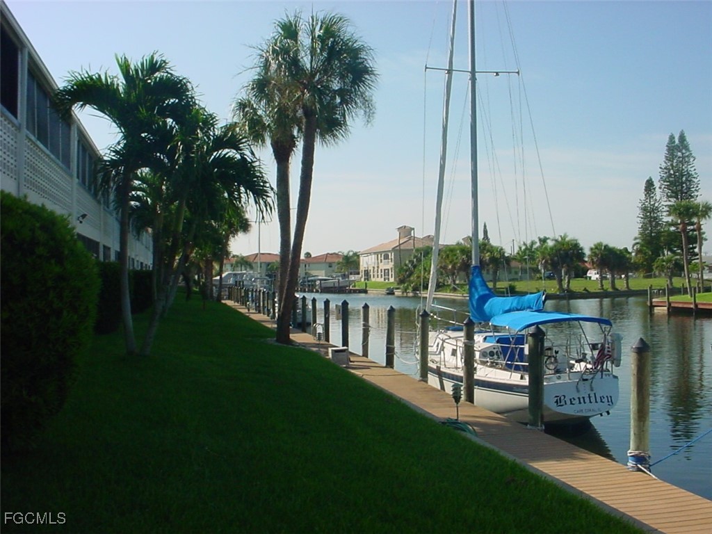 708 Victoria Drive, Unit 206 Cape Coral, FL 33904 - Photo 16 of 17 a view of a lake with a boat and palm trees