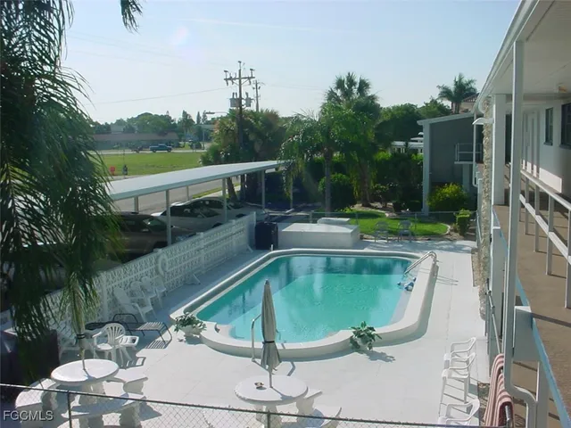 a view of a house with a yard and palm trees