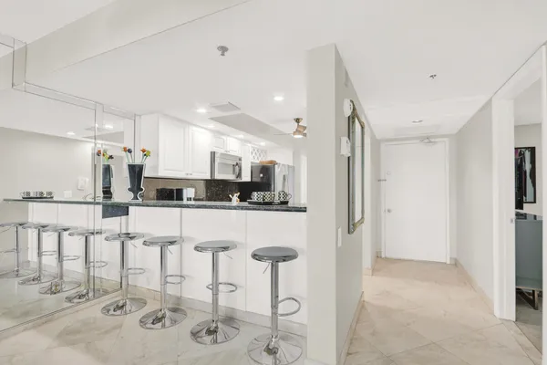 a kitchen with stainless steel appliances kitchen island granite countertop a refrigerator and cabinets