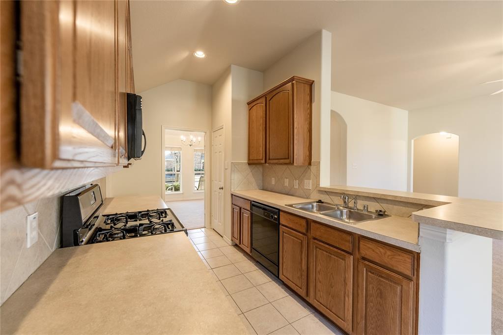 1627 Balboa Lane Allen, TX 75002 - Photo 11 of 23 a kitchen with a stove a sink and a refrigerator