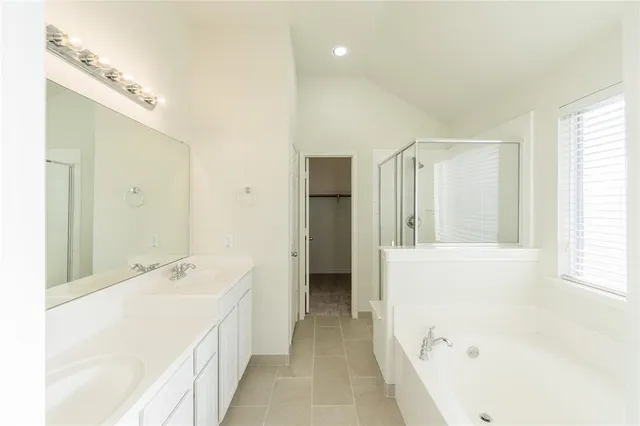 a spacious bathroom with a bathtub sink and mirror