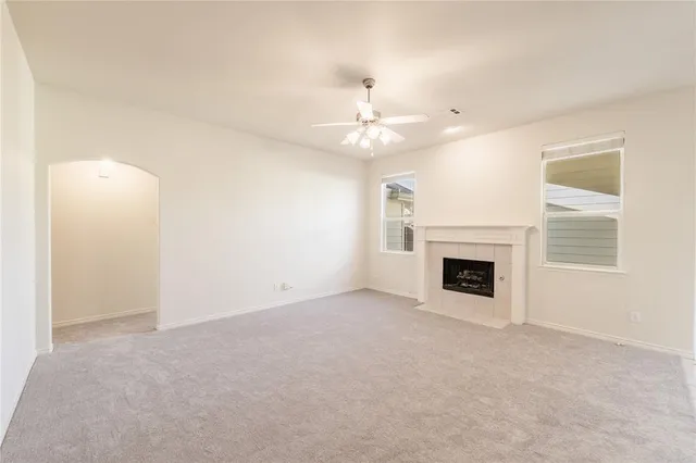 an empty room with a fireplace and fan