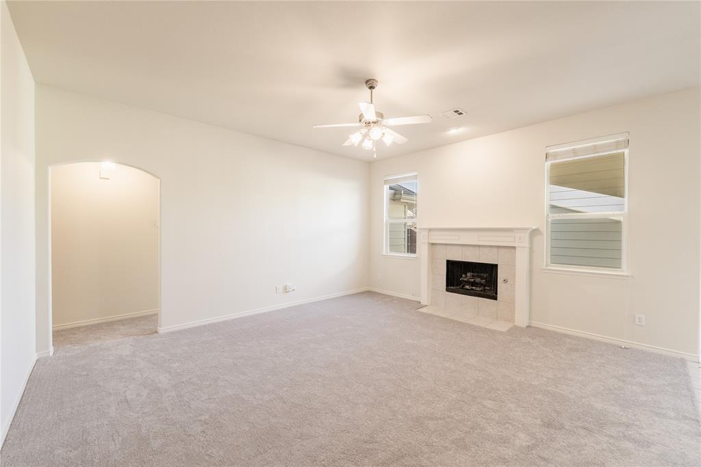 1627 Balboa Lane Allen, TX 75002 - Photo 8 of 23 an empty room with a fireplace and fan