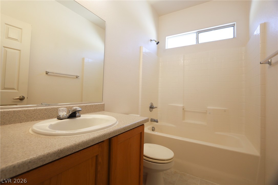 6472 Centennial Road Pahrump, NV 89048 - Photo 14 of 29 A well-lit bathroom features a functional vanity with ample counter space and a classic tub-shower combination.