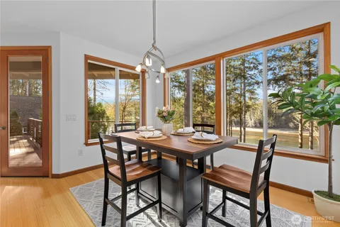 a view of a dining room with furniture large windows and wooden floor