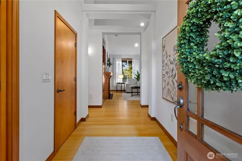 a view of a hallway with wooden floor and stairs
