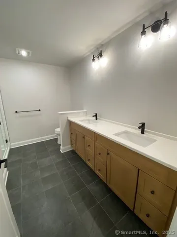 a spacious bathroom with a double vanity sink and mirror