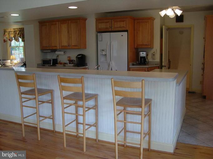 6904 Avondale Road Baltimore, MD 21212 - Photo 22 of 30 a kitchen with stainless steel appliances granite countertop a table chairs sink and cabinets
