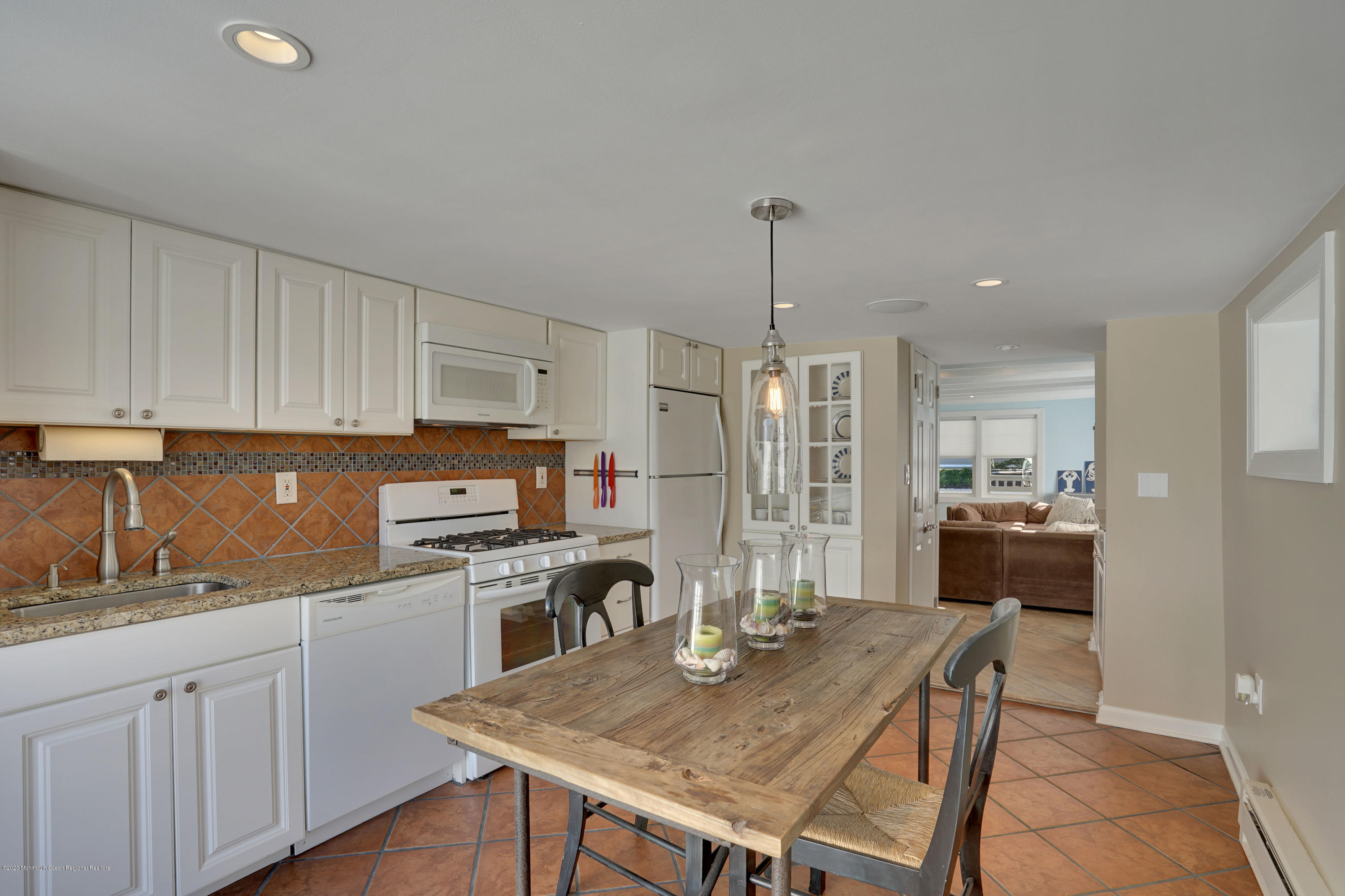 593 Brielle Road Manasquan, NJ 08736 - Photo 12 of 39 a kitchen with a table chairs refrigerator and cabinets