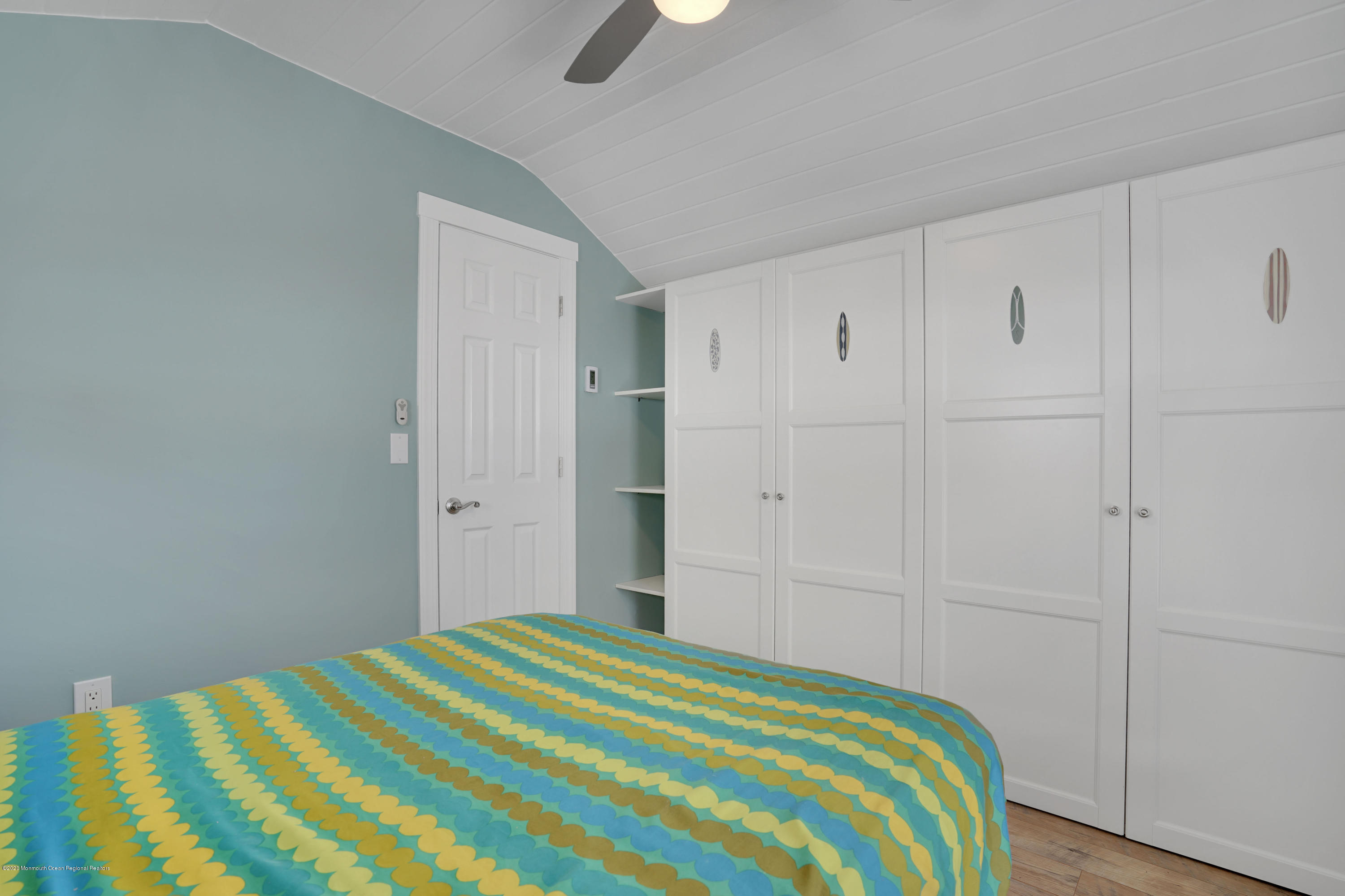 593 Brielle Road Manasquan, NJ 08736 - Photo 23 of 39 a bedroom with a bed and a chandelier