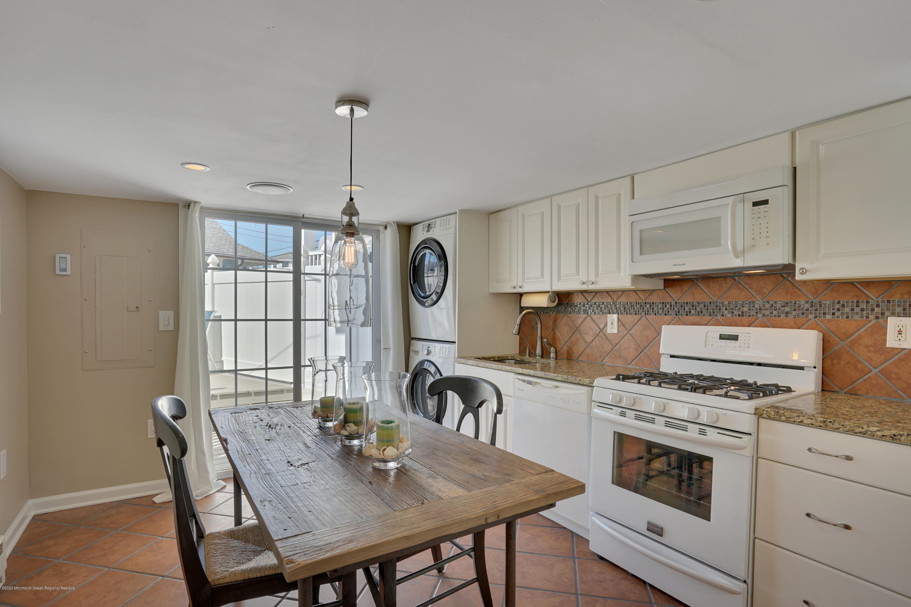 593 Brielle Road Manasquan, NJ 08736 - Photo 10 of 39 a kitchen with granite countertop a stove a sink dishwasher a dining table and chairs with wooden floor
