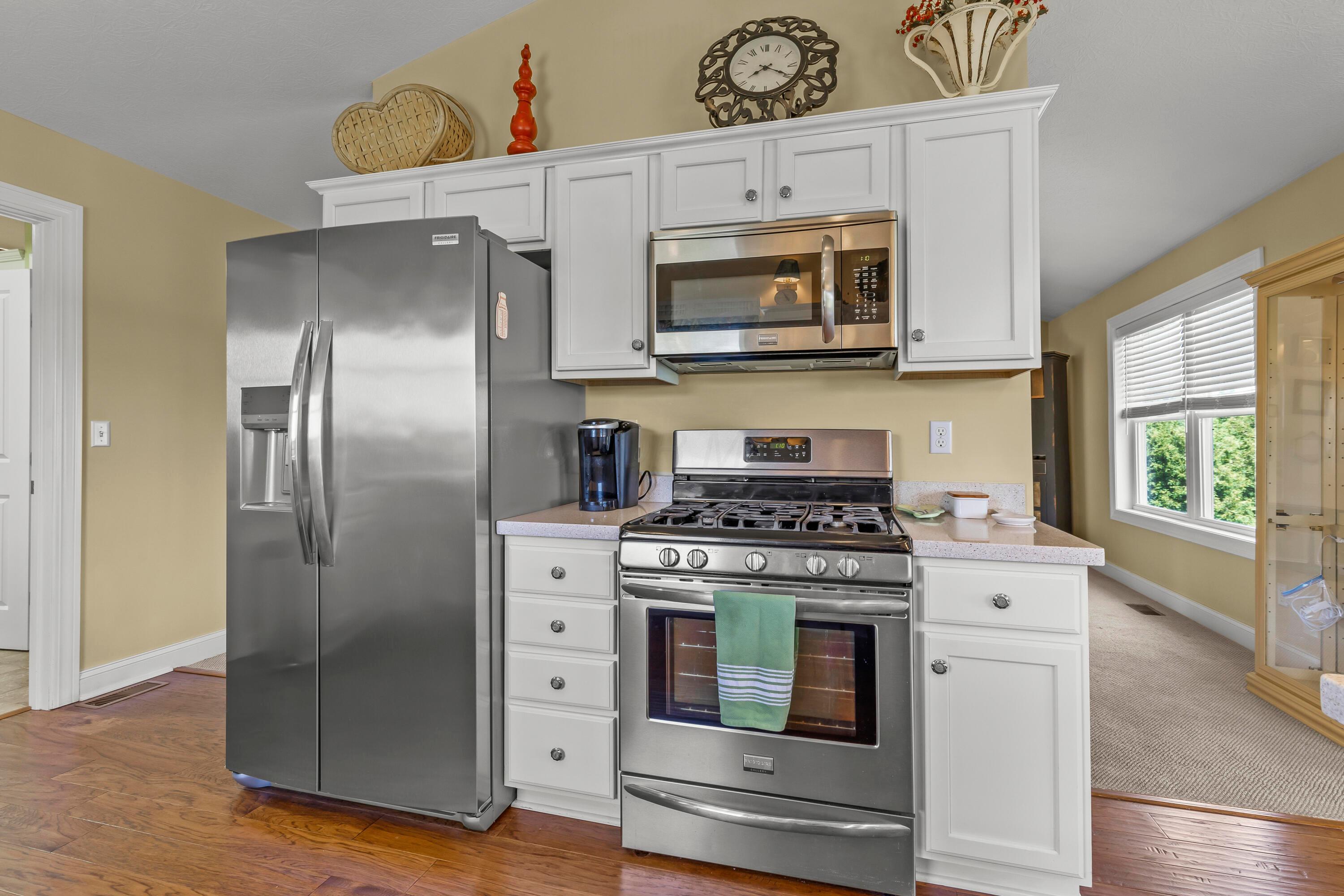 3582 Panhandle Road Delaware, OH 43015 - Photo 26 of 65 • New englewood flooring ~ 2015 • Ivory painted walls • Cathedral ceiling • New quartz countertops ~ 2015 • Can lighting • White cabinets • Double bowl, stainless steel sink with sprayer • Frigidaire® dishwasher • New Frigidaire® refrigerator ~ 2024 • Frigidaire® microwave • Frigidaire® gas range • Breakfast bar ledge • Disposal • Pendant lights over Dinette • Electric outlet above cabinets