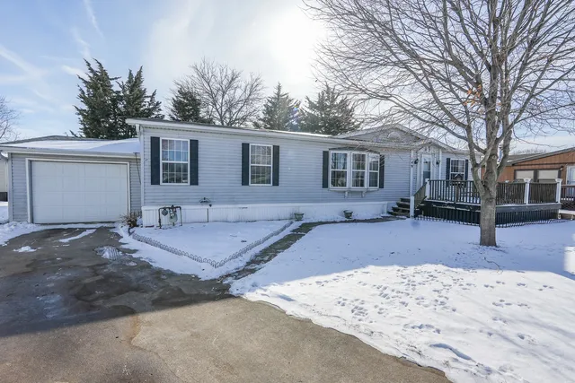 a front view of a house with a yard covered with snow