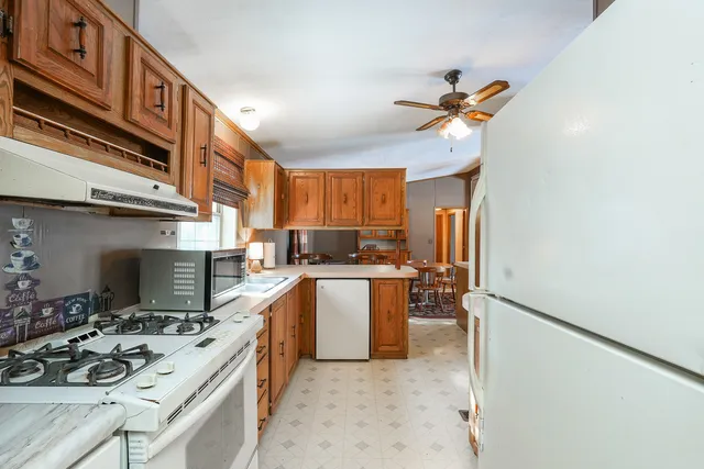 a kitchen with stainless steel appliances a sink a stove a refrigerator and cabinets