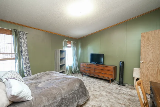 a bedroom with a bed and a television