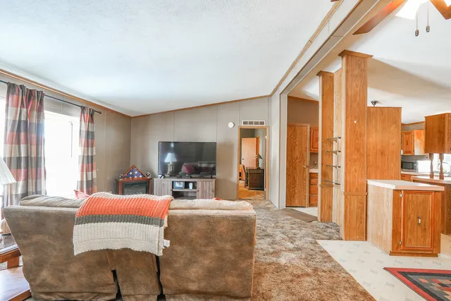 a living room with furniture a large window and a flat screen tv