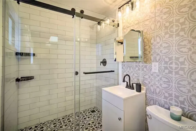 a bathroom with a sink a toilet and shower
