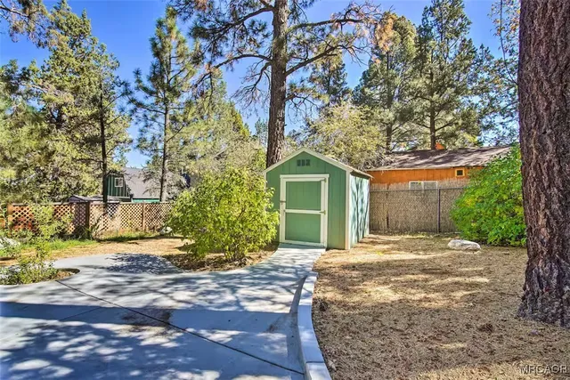 a front view of a house with a yard and tree s
