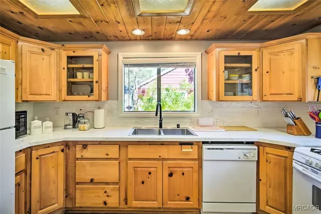 a kitchen with granite countertop a sink stainless steel appliances cabinets and a large window