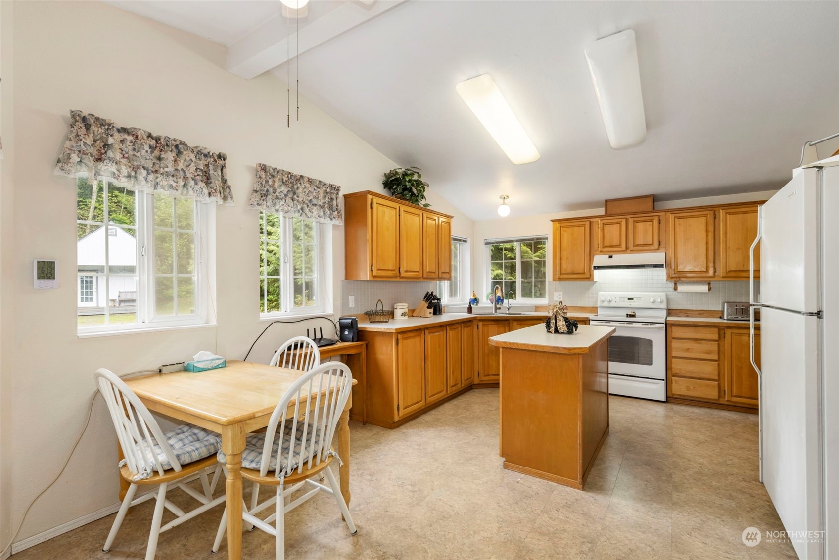 2123 East Quilcene Road Quilcene, WA 98376 - Photo 8 of 37 a kitchen with stainless steel appliances granite countertop a kitchen island a stove a table and chairs