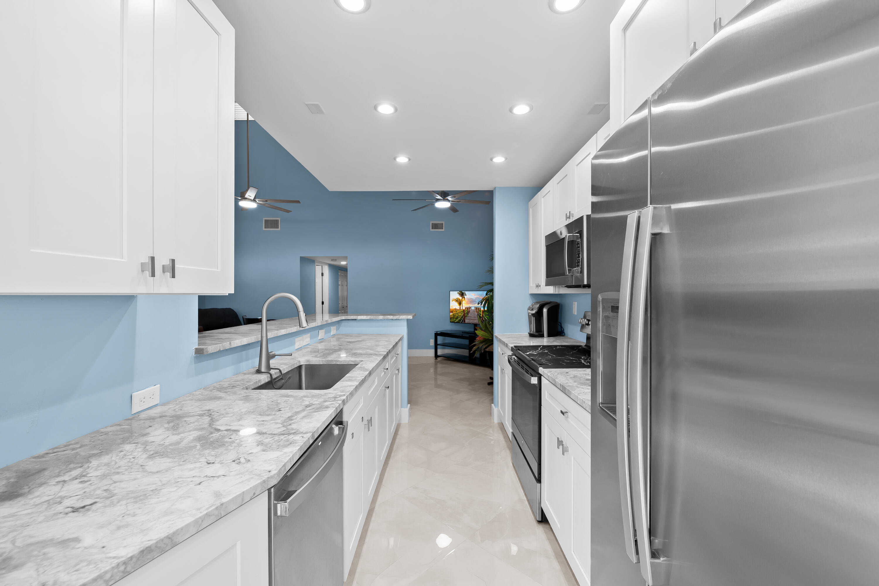 14079 Nesting Way, Unit B Delray Beach, FL 33484 - Photo 11 of 26 a kitchen with stainless steel appliances granite countertop a sink and a refrigerator