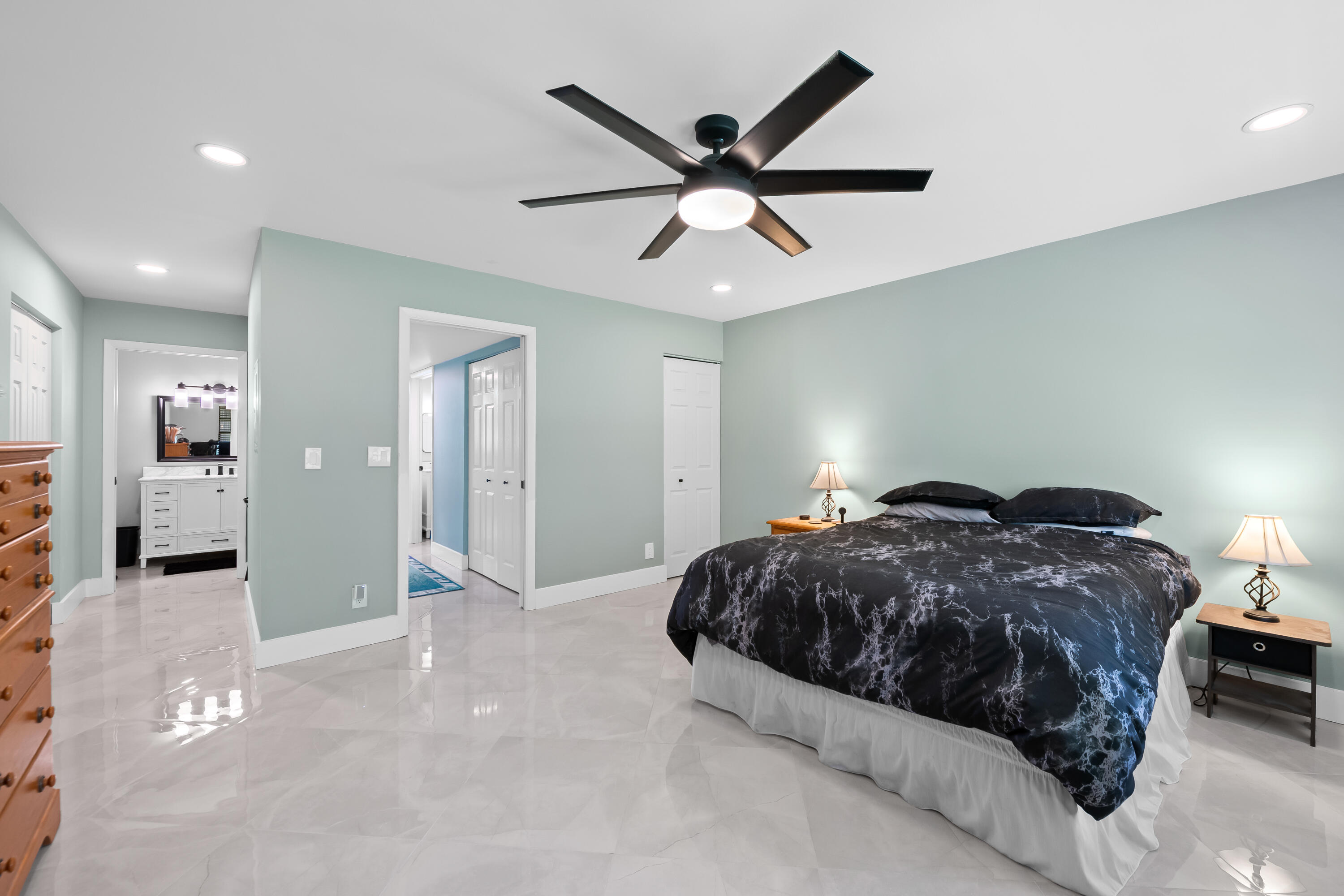 14079 Nesting Way, Unit B Delray Beach, FL 33484 - Photo 17 of 26 a spacious bedroom with a bed and a ceiling fan