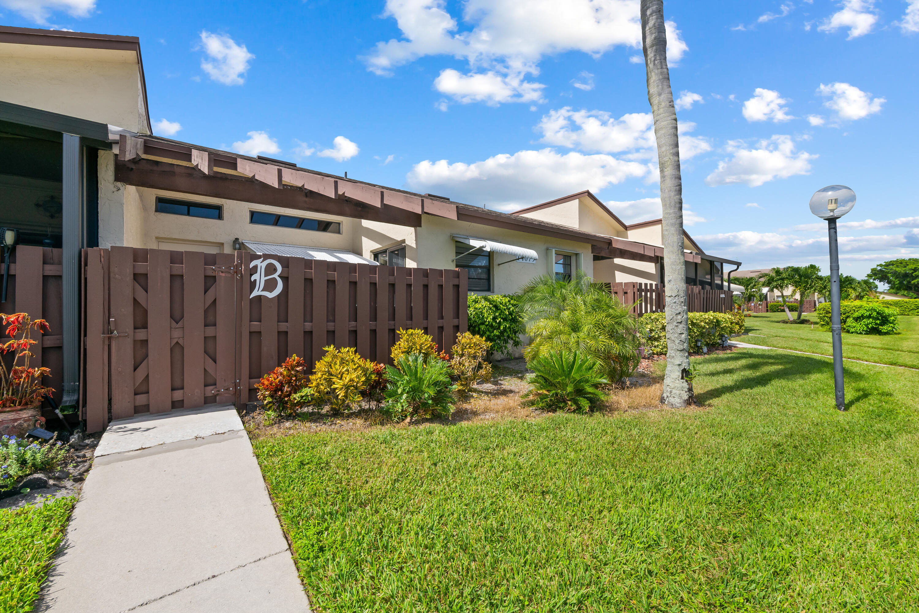 14079 Nesting Way, Unit B Delray Beach, FL 33484 - Photo 2 of 26 a front view of a house with a yard