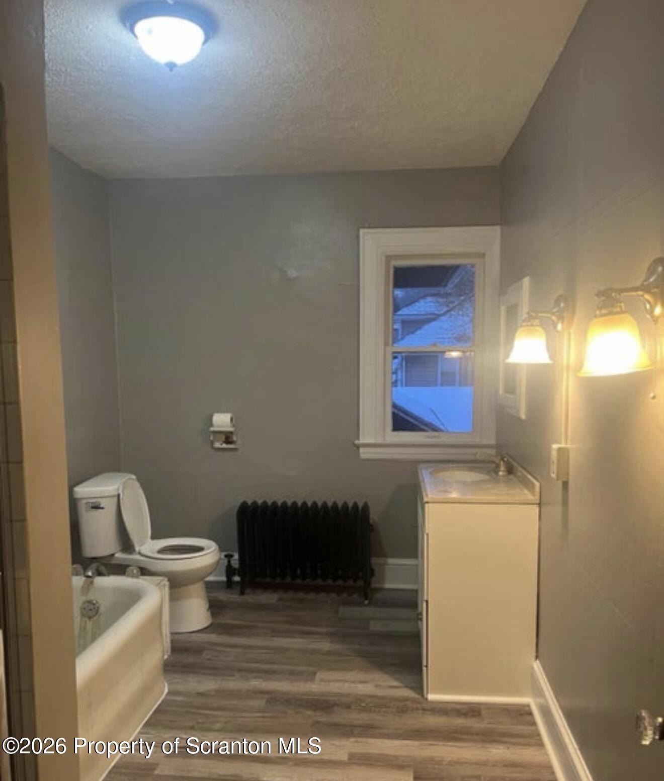 85 Main Street Olyphant, PA 18447 - Photo 15 of 29 a bathroom with a toilet a sink and mirror