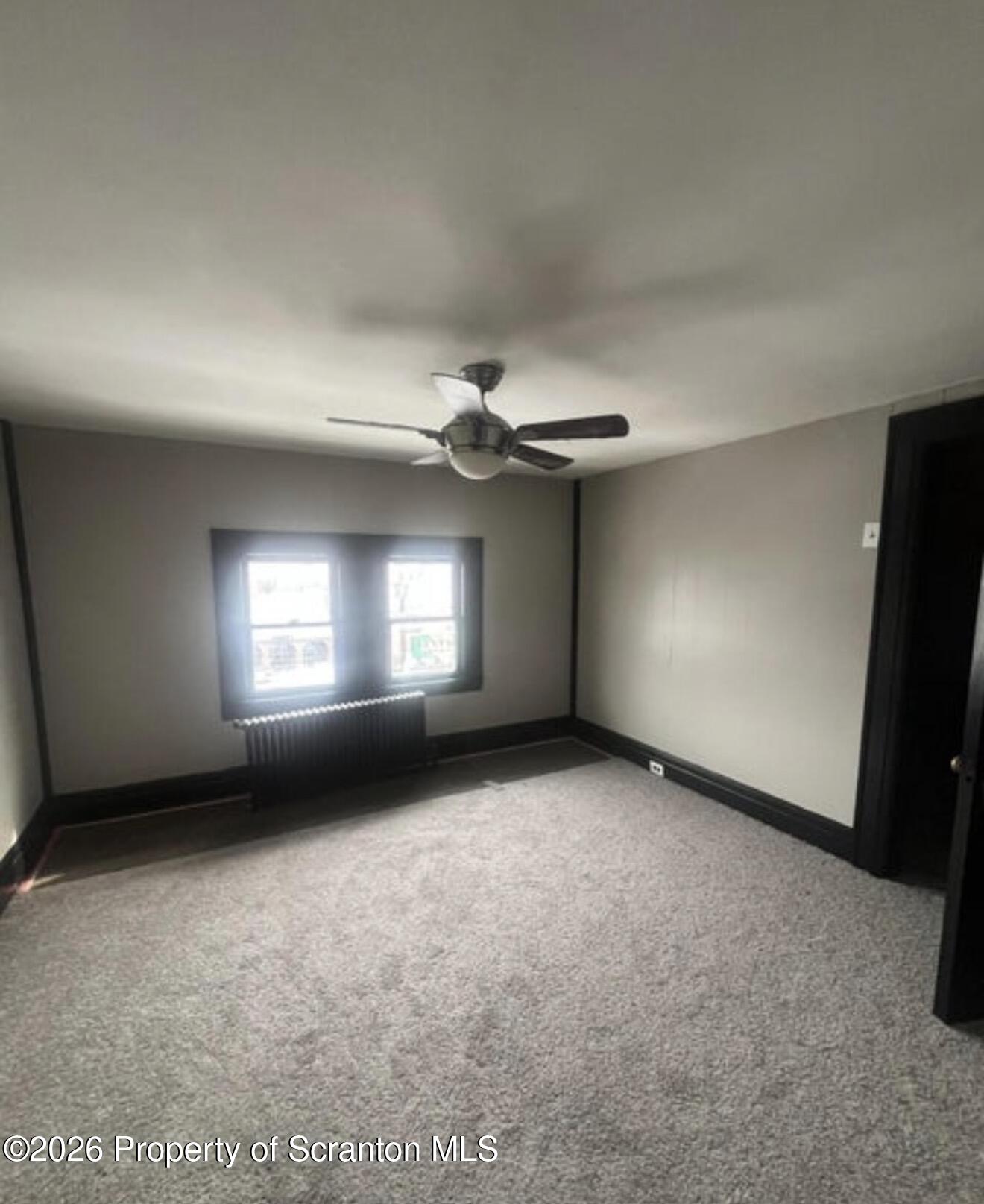 85 Main Street Olyphant, PA 18447 - Photo 20 of 29 an empty room with windows and fireplace
