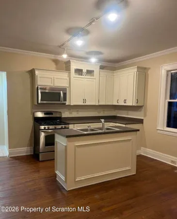 a kitchen with stainless steel appliances granite countertop a stove a sink and a microwave