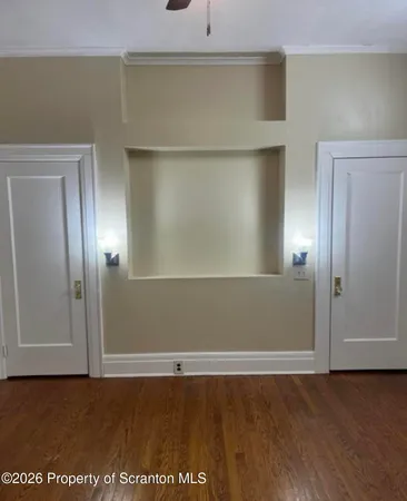 an empty room with wooden floor and closet