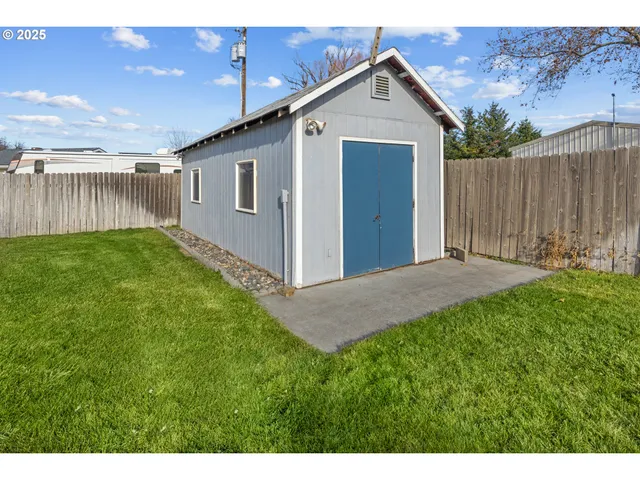 a view of backyard of house with wooden fence