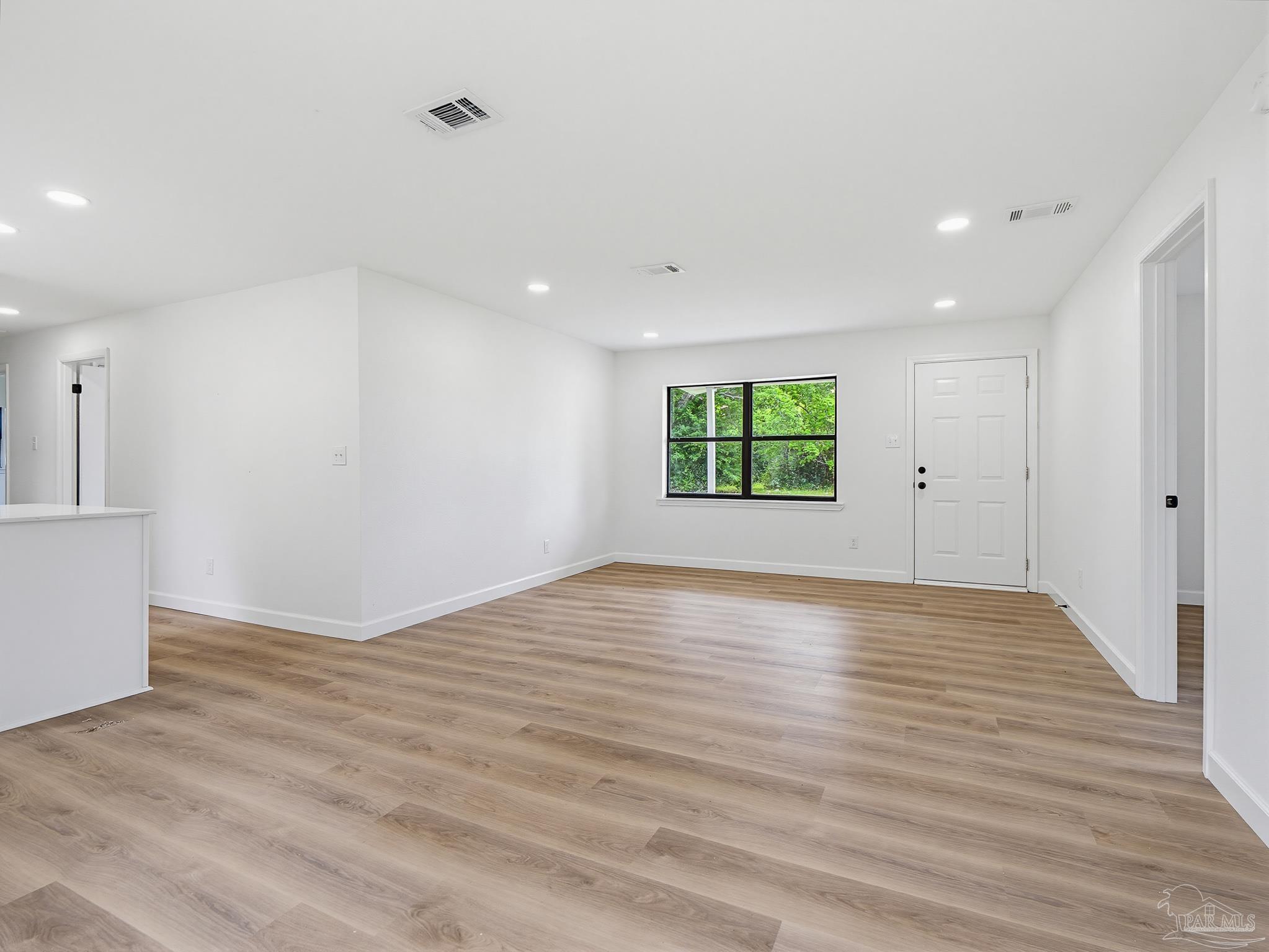 125 Madrid Road Cantonment, FL 32533 - Photo 4 of 16 a view of an empty room with wooden floor and a window