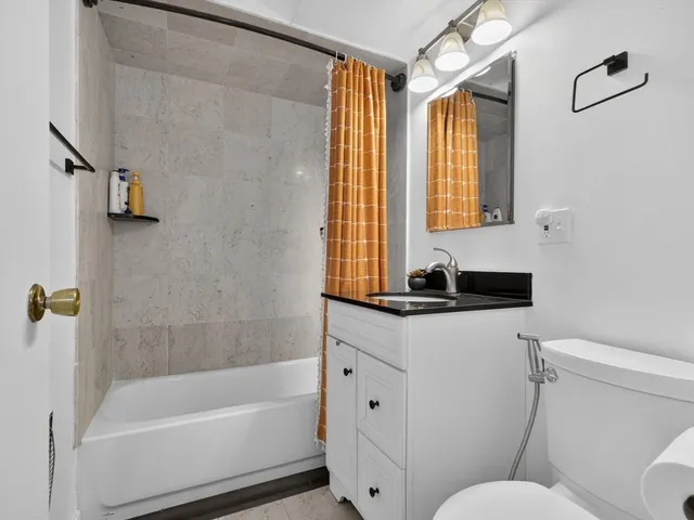 a bathroom with a granite countertop sink toilet and shower