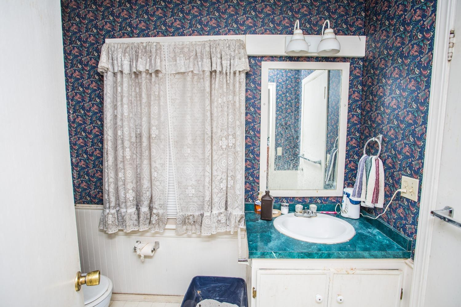 2422 33rd Street Lubbock, TX 79411 - Photo 23 of 35 a bathroom with a granite countertop sink and a mirror