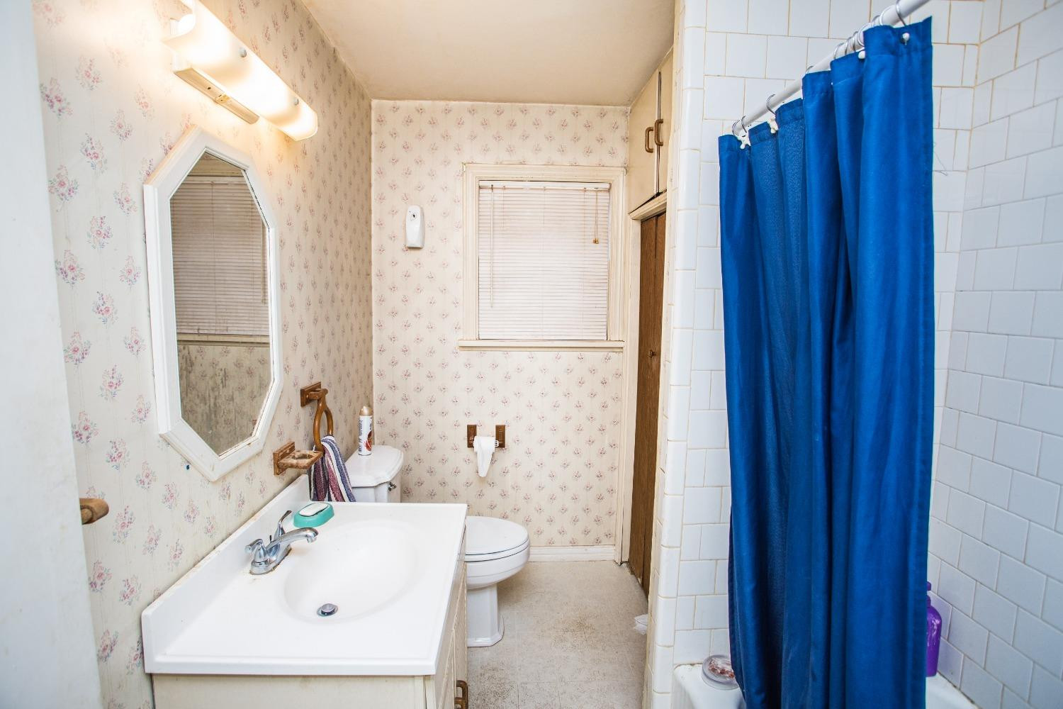 2422 33rd Street Lubbock, TX 79411 - Photo 24 of 35 a bathroom with a sink a mirror and a shower
