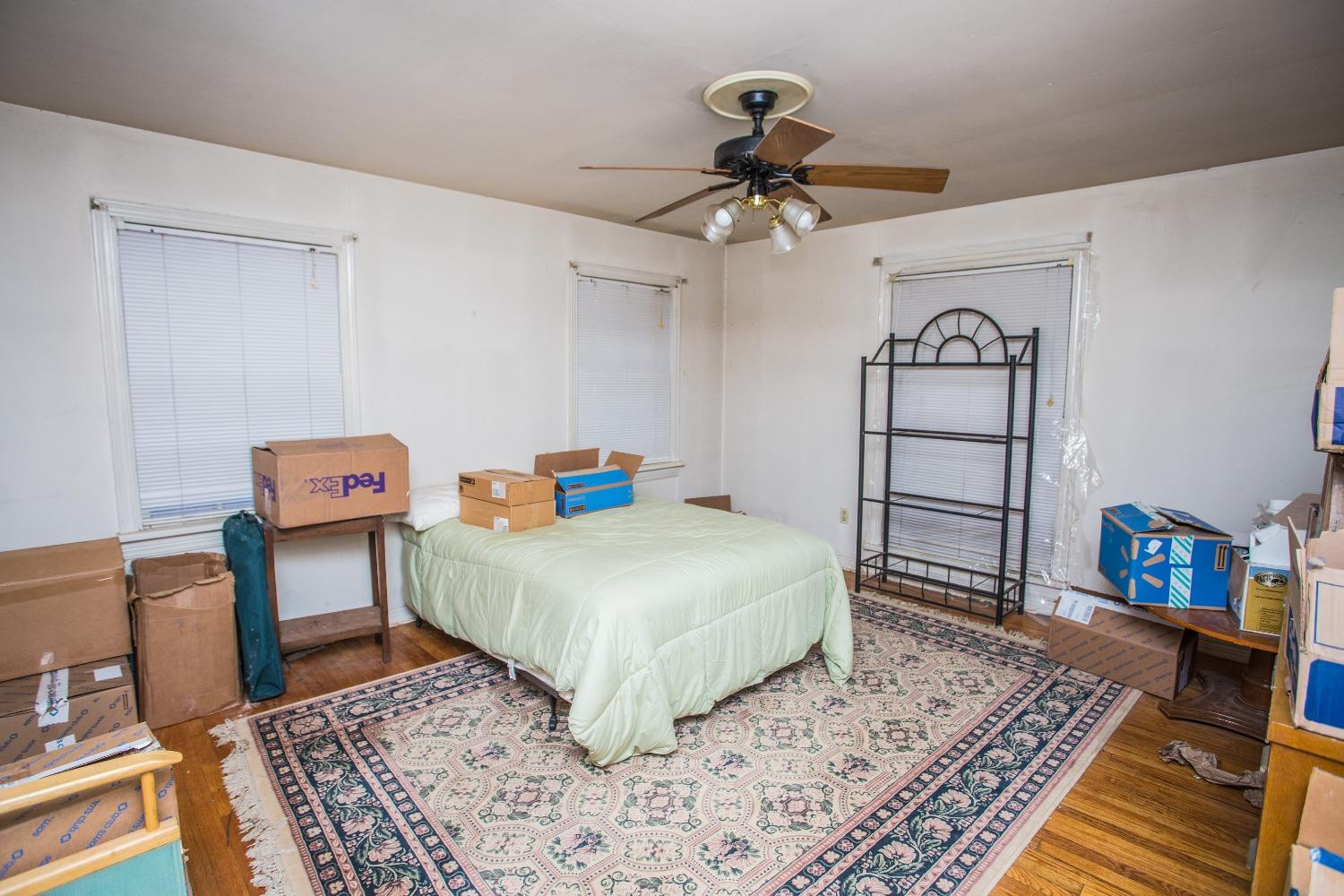 2422 33rd Street Lubbock, TX 79411 - Photo 26 of 35 a bedroom with a bed a dresser and wooden floor