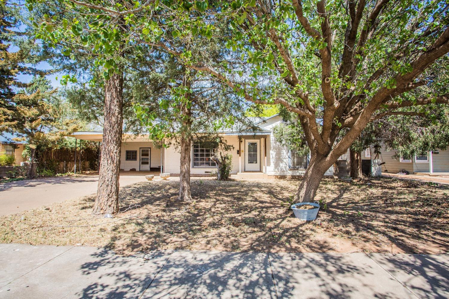 2422 33rd Street Lubbock, TX 79411 - Photo 6 of 35 a tree in front of a white house