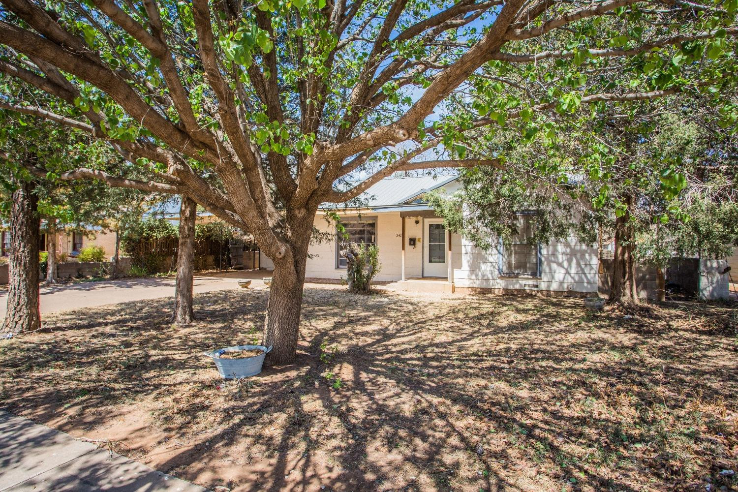 2422 33rd Street Lubbock, TX 79411 - Photo 7 of 35 a tree in front of a white house