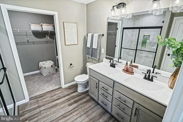 a bathroom with a sink a toilet and shower a mirror