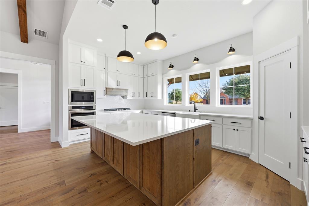 509 Emma Lane Grandview, TX 76050 - Photo 13 of 35 a kitchen with a stove and a wooden floor