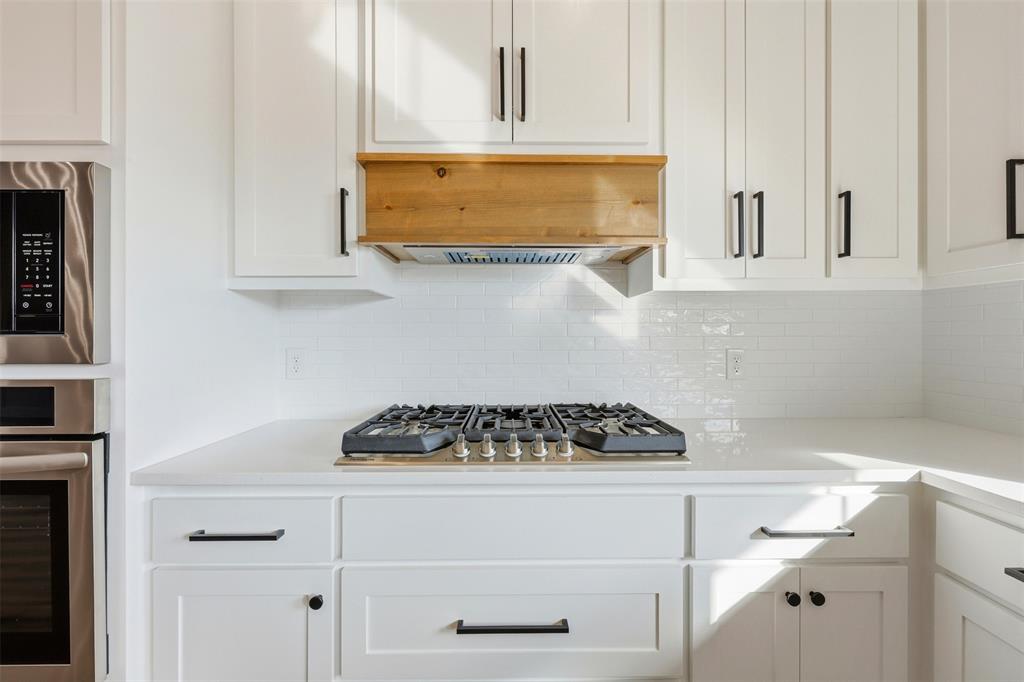 509 Emma Lane Grandview, TX 76050 - Photo 15 of 35 a kitchen with white cabinets and a stove