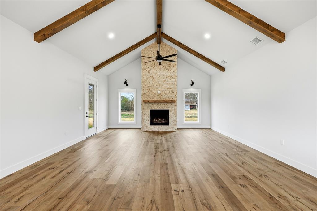 509 Emma Lane Grandview, TX 76050 - Photo 10 of 36 a view of a livingroom with wooden floor and a fireplace